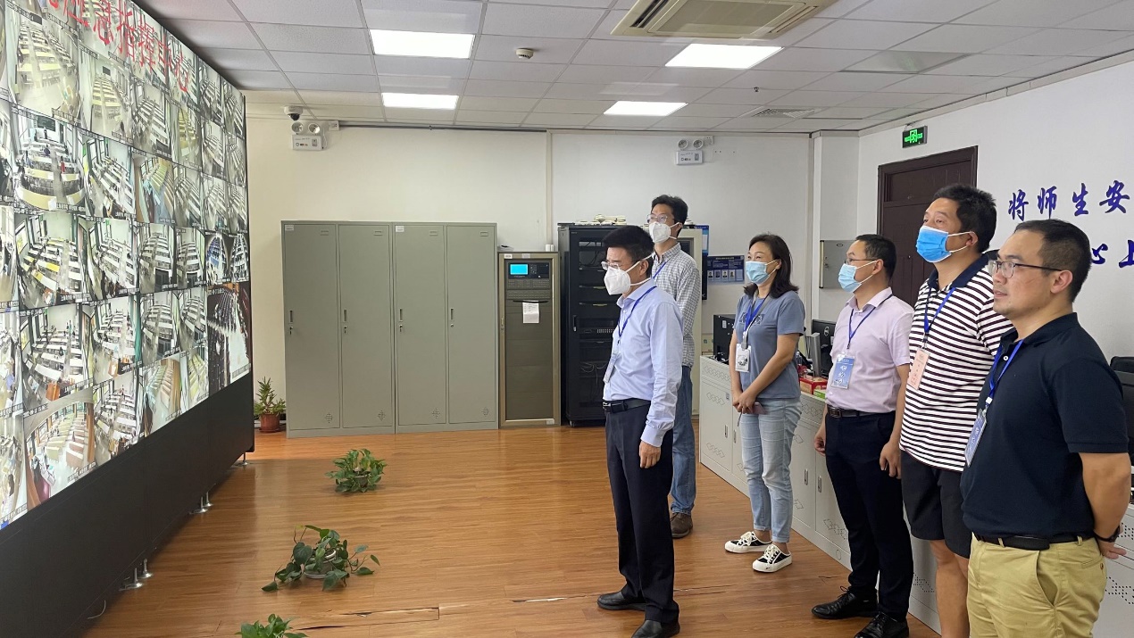 （图为副校长陈剑峰、上海市教育考试院外派巡考员黄熙辰与教务处其他工作人员一同查看考场监控情况）