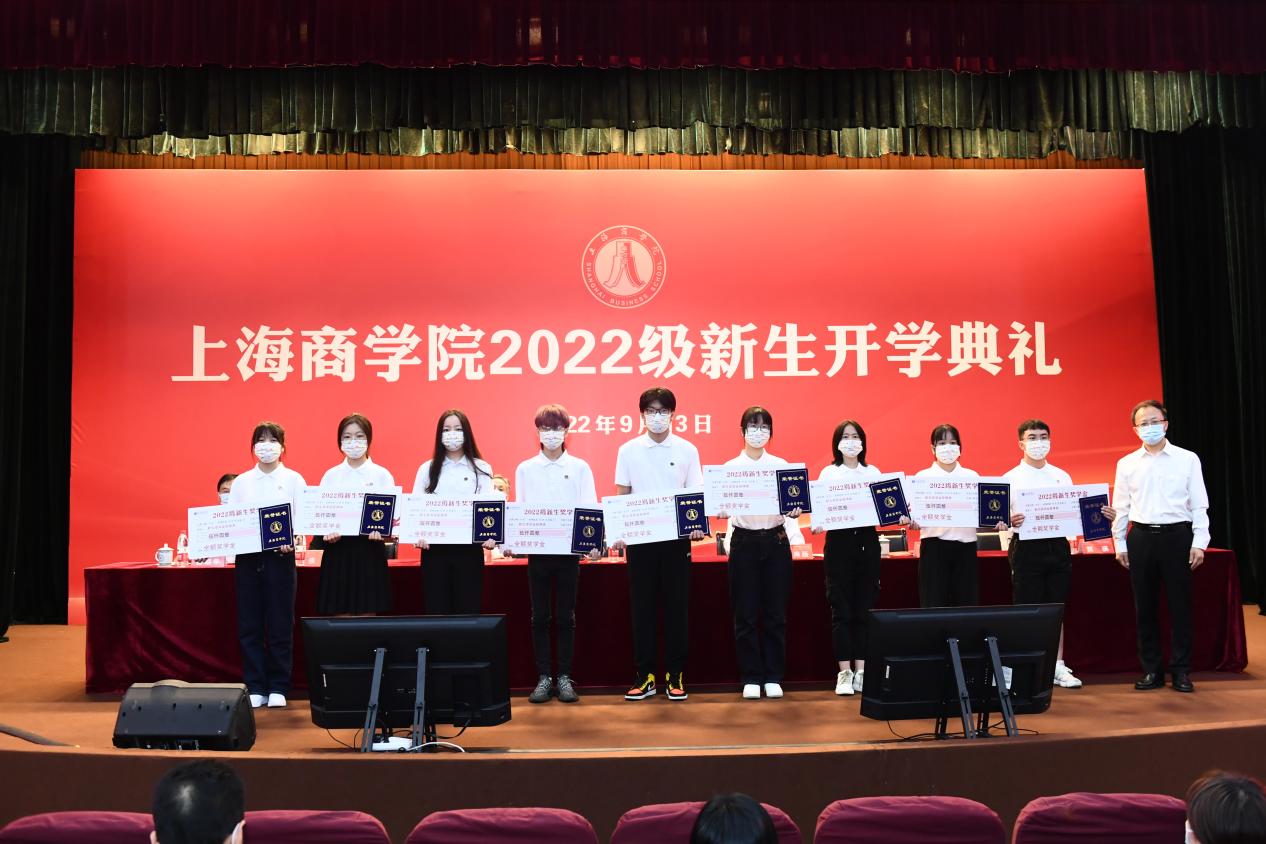 沈大明为新生奖学金获奖代表颁发奖学金并佩戴校徽